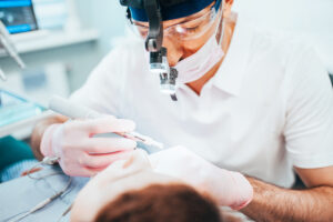 Dentist cleans tooth canals of patient