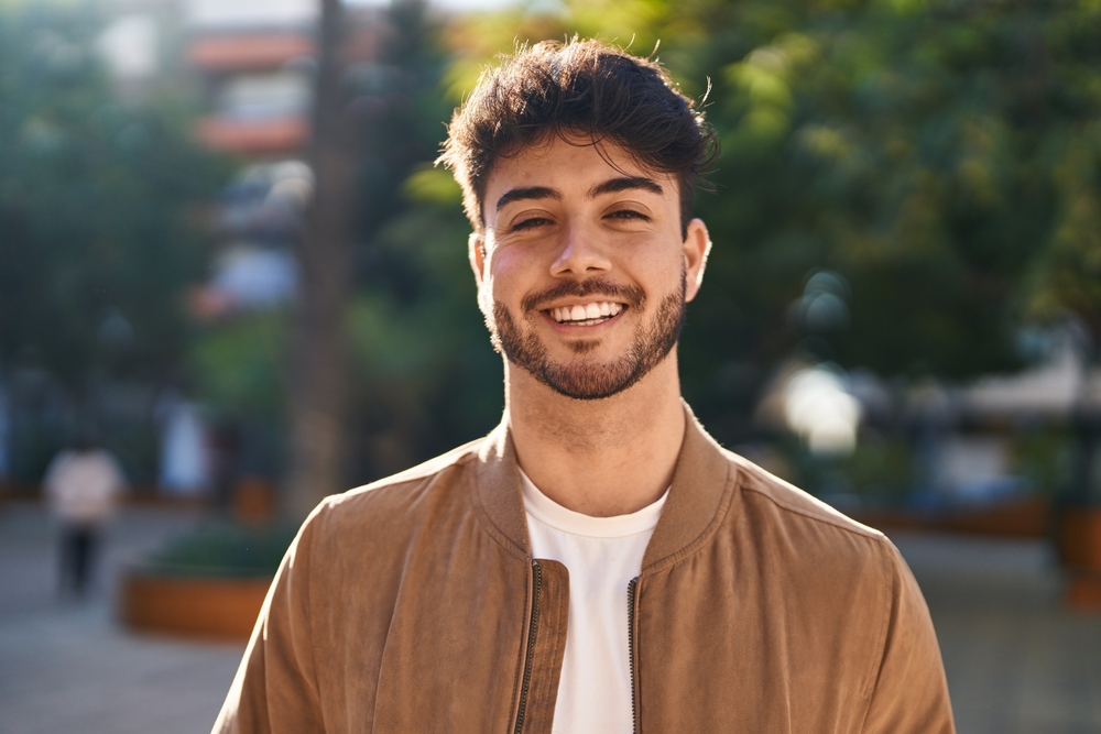 Young man smiling confident standing at park